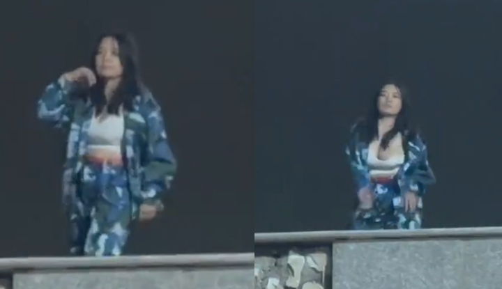 Female college student performs a lively dance during military training class, jumping with 